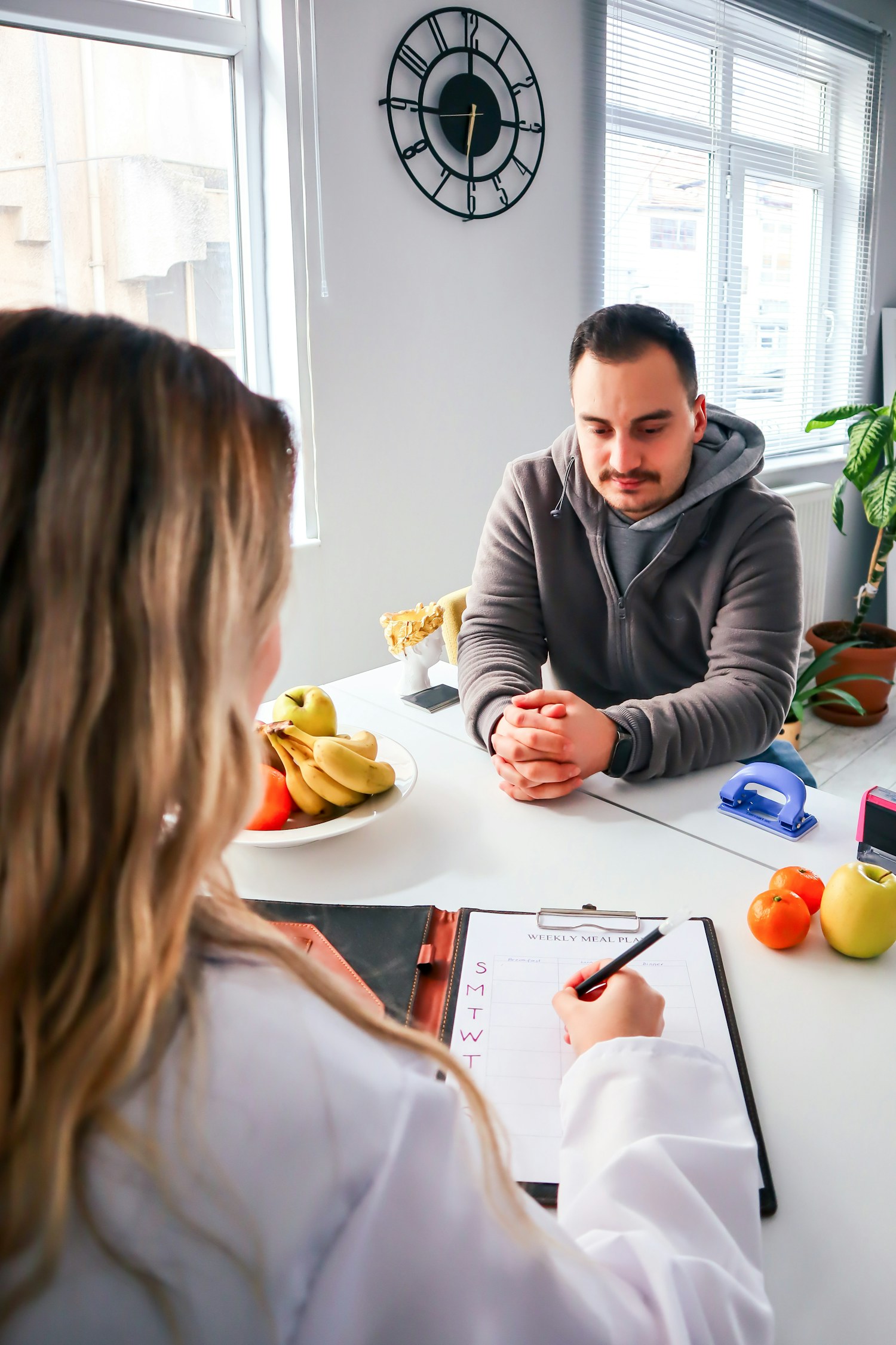 A naturopath in conversation with a client in a calm, sunlit Montreal practice